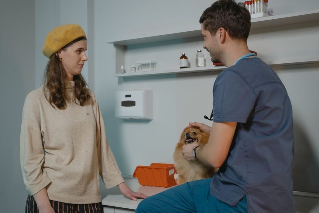 Vet holding a Pomeranian while talking to its owner in a clinic - ask a vet before giving human painkillers